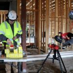 Young's Mechanical plumbers cutting and prepping pipe on a commercial job site