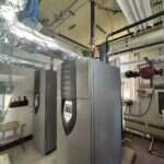 Commercial boilers and water heaters in a mechanical room installed by Young's Mechanical — mechanical room, boiler, water heater