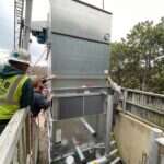 Young's Mechanical technician rigging a commercial rooftop packaged HVAC unit — rooftop, RTU