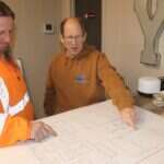 Young's Mechanical Solutions staff reviewing commercial project plans — leadership, planning