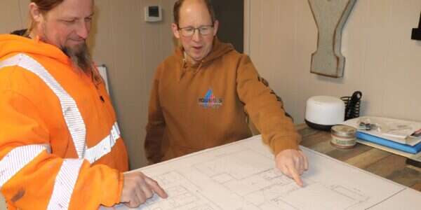 Young's Mechanical Solutions staff reviewing commercial project plans — leadership, planning