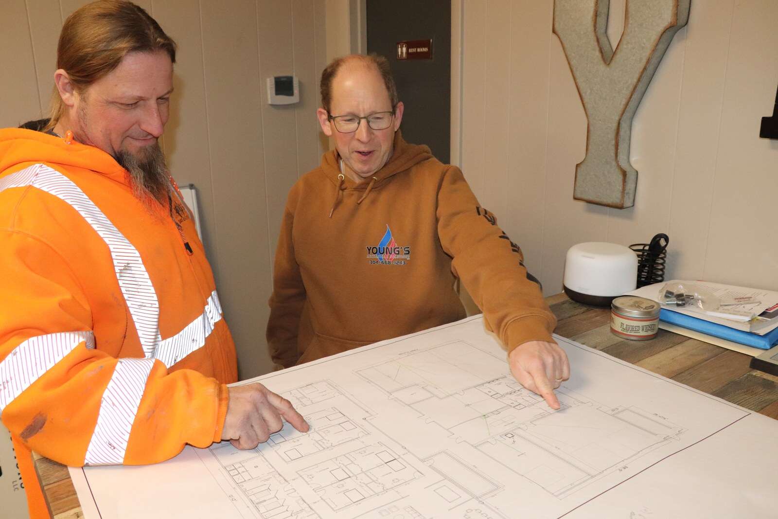 Young's Mechanical Solutions staff reviewing commercial project plans — leadership, planning