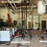 Commercial mechanical room piping and tanks installed by Young's Mechanical Solutions — mechanical room, piping