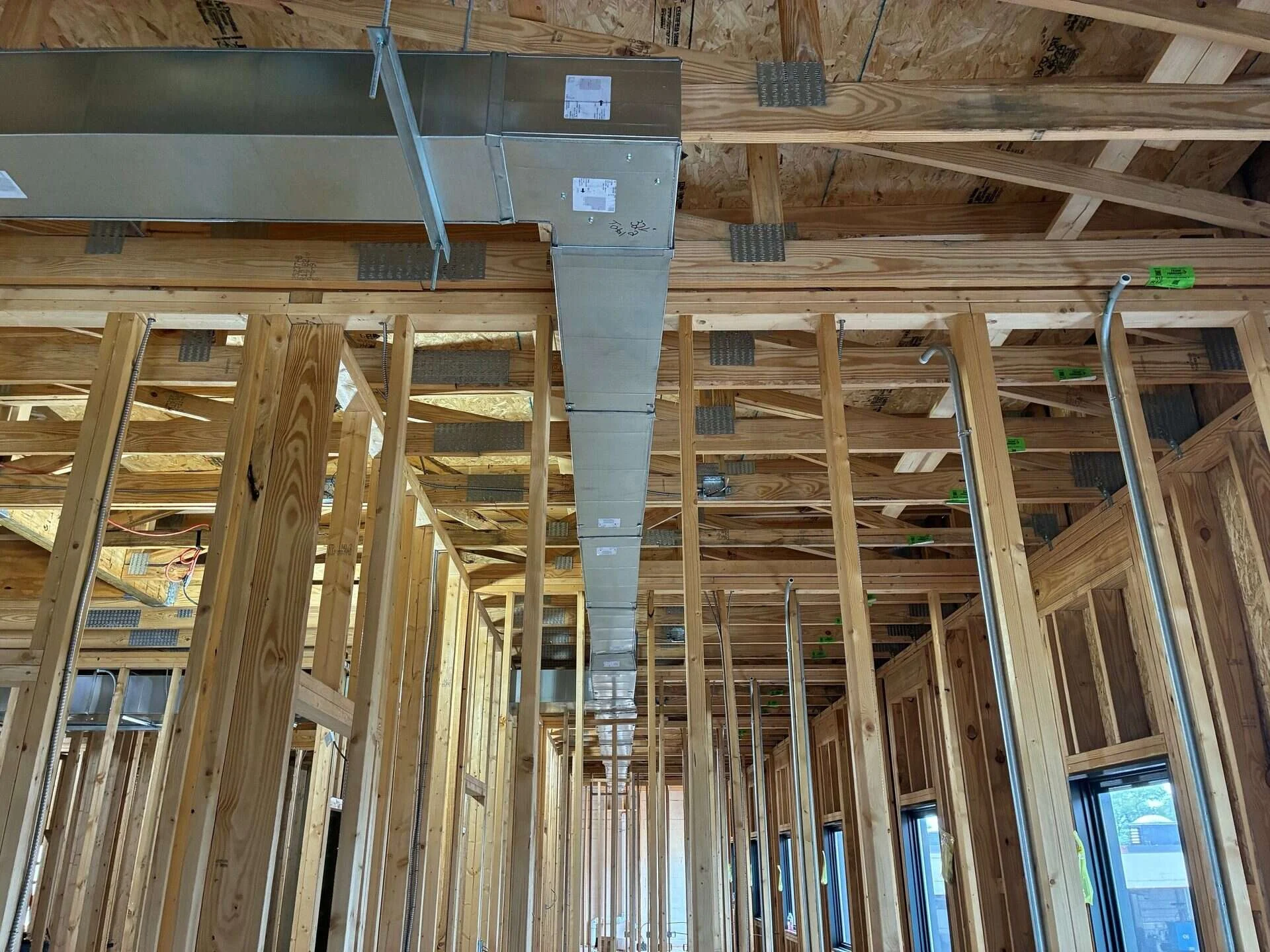 Main sheet metal supply trunk with reducing transitions running the length of a commercial building under construction