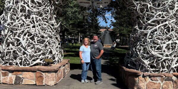 Young's Mechanical Solutions team member Mark Dean and his wife under the elk antler arch in Jackson Hole, Wyoming